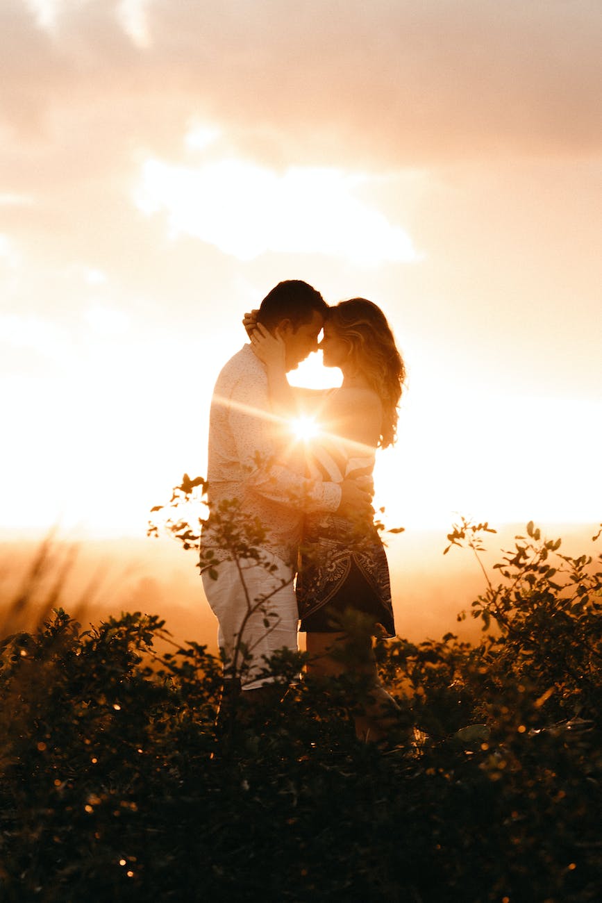 couple standing beside plants during golden hour