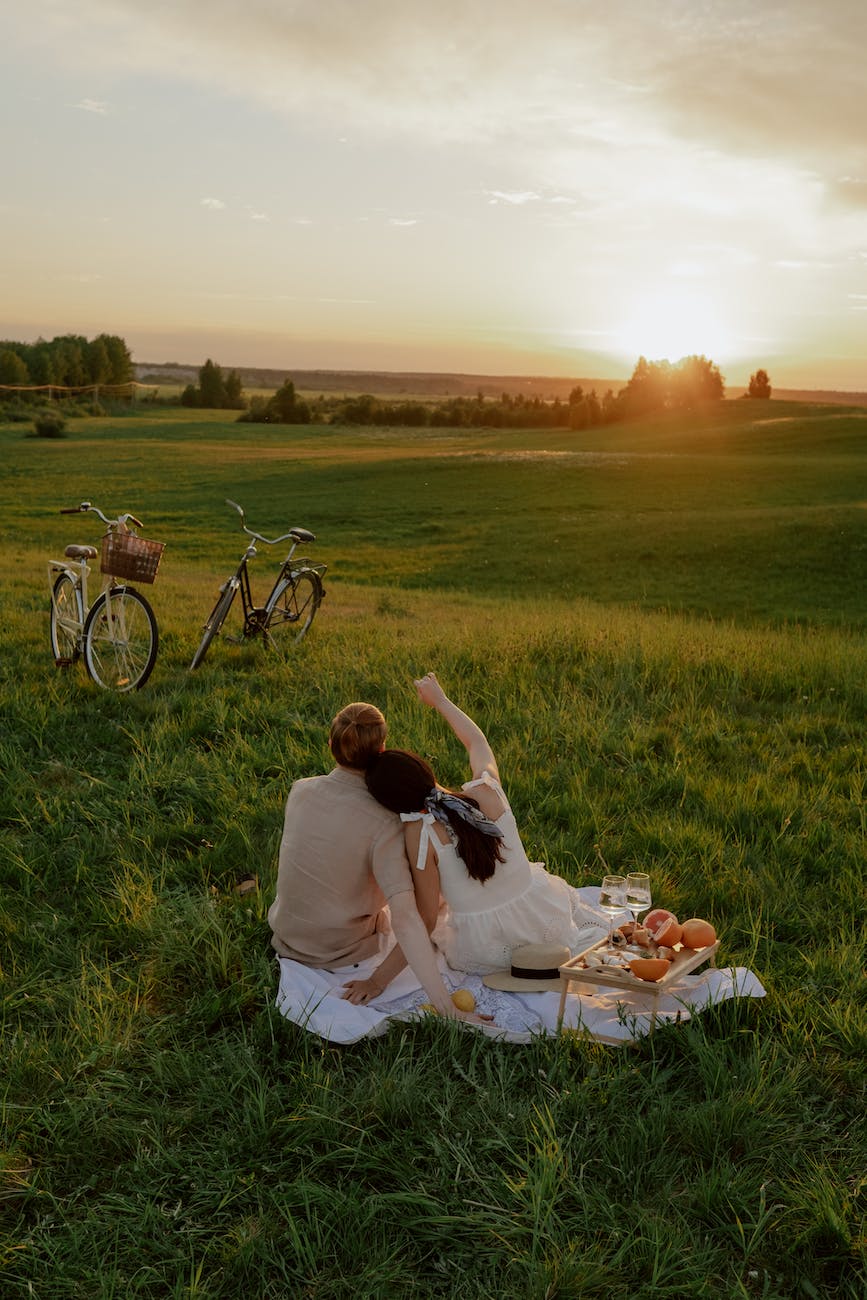 a couple sitting on the grass field