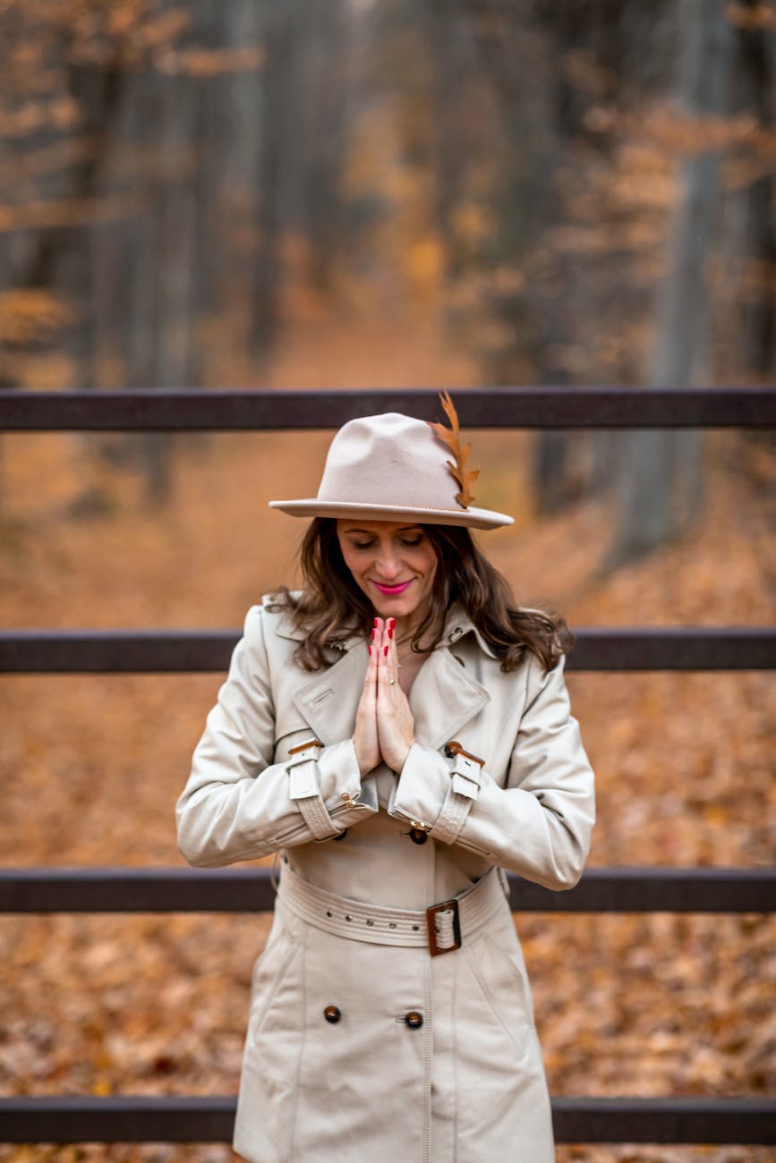 a woman in a coat praying