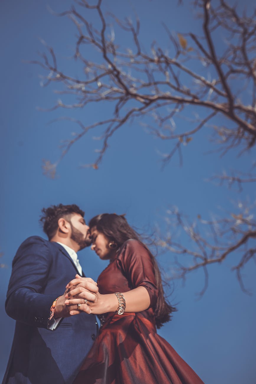 man and woman standing outside near bare tree